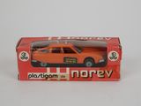 une petite voiture orange dans une boîte posée sur une surface blanche