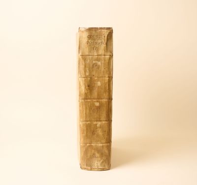 un vieux livre posé sur une table à côté d'un mur blanc