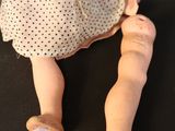 a doll that is sitting next to a doll