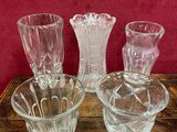 trois vases en verre posés sur une table, sur fond rouge
