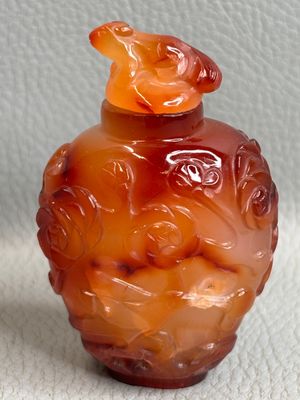 un vase en verre orange orné d'un oiseau