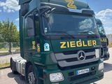 a green truck that is parked on the side of the road