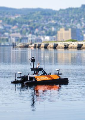 un petit bateau orange et noir flottant sur l'eau