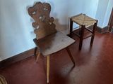 two wooden chairs in a room with a red floor