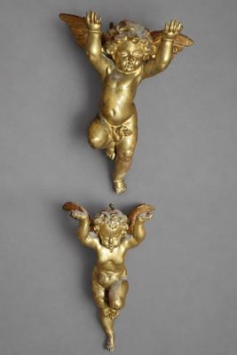 deux statues d'anges en or accrochées l'une à côté de l'autre sur un mur