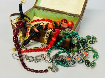 a box filled with assorted jewelry on a white surface