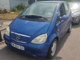 une petite voiture bleue garée sur le bord de la route