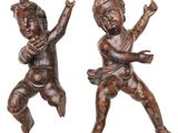 paire de figurines anciennes en bois représentant des bébés jouant ensemble