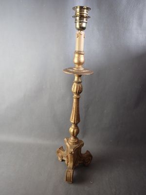 antique brass candle holder with a candle on top of it
