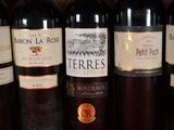 several bottles of wine are lined up in a row on a shelf