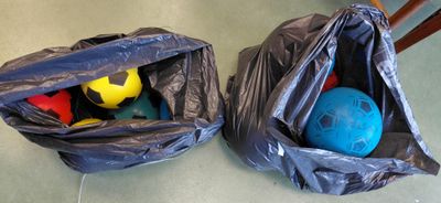 deux sacs posés par terre, contenant des balles