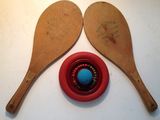 Deux cuillères en bois sont posées sur une table, à côté d'un bol rouge.