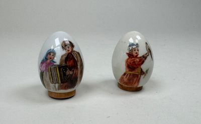 paire d'œufs en porcelaine ornés de motifs peints sur fond blanc