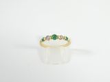 an emerald and diamond ring on a white background