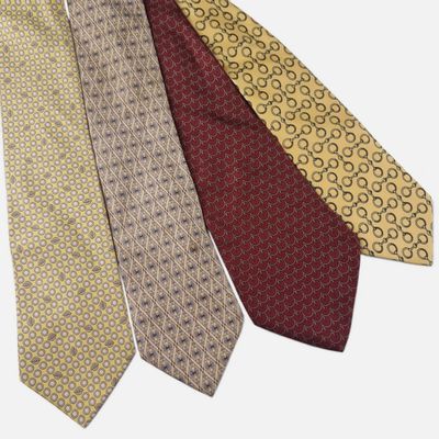 trois cravates de couleurs différentes sont alignées sur une surface blanche