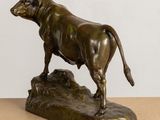 bronze statue of a bull on a rock on a table