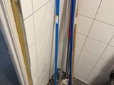 two brooms and a mop on the floor in the bathroom