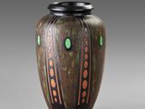 a brown vase with green and orange designs on it
