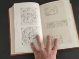 a person that is holding a book with drawings on it