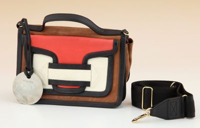 a purse and a key on a white surface