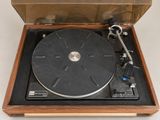 a record player sitting in a wooden box on a white surface