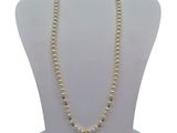 a close up of a mannequin with a pearl necklace on it