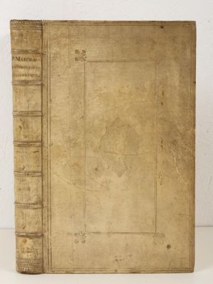 an old book sitting on top of a table next to a white wall
