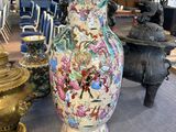 un grand vase posé sur une table, à côté d'autres objets