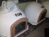 two pizza ovens sitting next to each other on the floor