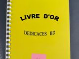 the yellow book is sitting on the table with a pink sticker on it