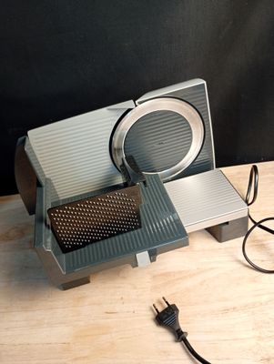 a silver and black toaster sitting on top of a wooden table