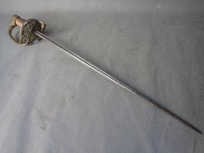 une longue épée dont la poignée métallique se détache sur un fond blanc