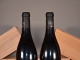 two bottles of wine sitting next to each other on a table