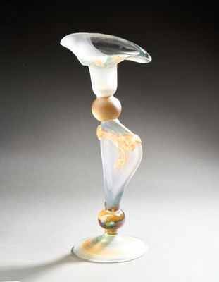 a glass vase sitting on a table with a black background