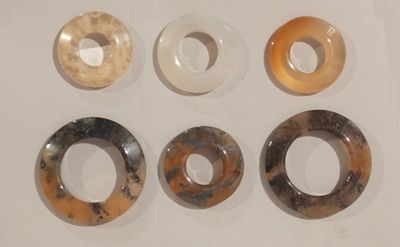 five donuts on a white surface with a hole in the middle of them