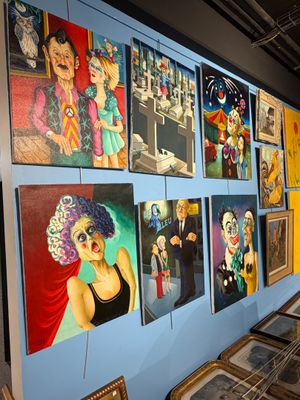 de nombreux tableaux accrochés au mur d'une pièce où sont accrochés des tableaux