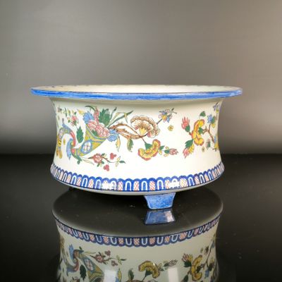 a white bowl with a blue rim on a black table