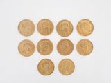 a close up of a bunch of gold coins on a white surface