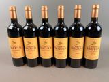 six bottles of red wine are lined up in a row