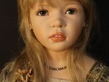 blond haired doll with blue eyes and a gold dress