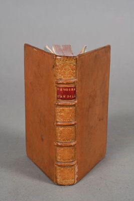 an old book sitting on top of a table next to a gray wall