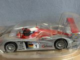 a toy car in a clear plastic case on a table