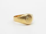 a close up of a gold signet ring with a diamond