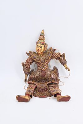 une figurine représentant une personne assise sur une surface blanche