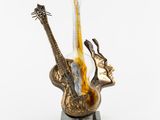 une sculpture représentant une guitare et une basse posées sur un socle