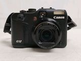 a black camera sitting on a table with a strap around it