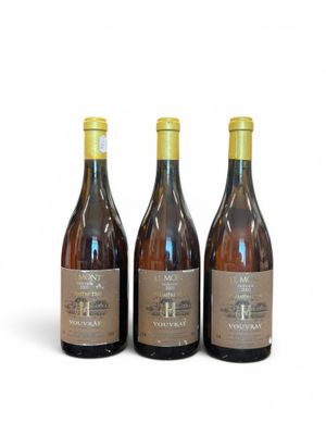 three bottles of wine sitting next to each other on a white surface