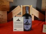 a bottle of liquor sitting on a table next to wooden crates