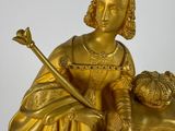 a gold statue of a woman with a crown on top of a clock