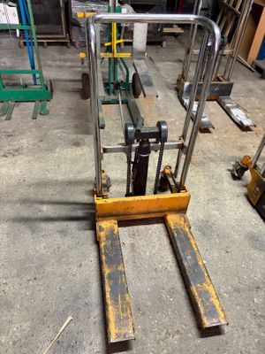 a fork lifter that is sitting in a warehouse